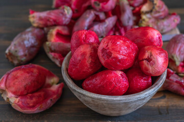 Peeled Opuntia fruits (Prickly pears) on wooden background.
