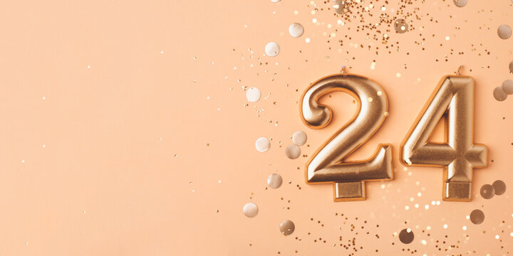24 years celebration. Greeting banner. Gold candles in the form of number twenty four on peach background with confetti.