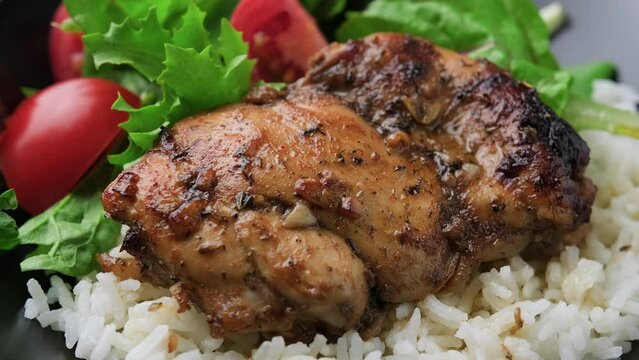 Baked balsamic chicken thighs with rice and vegetables. Rotating video