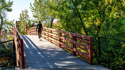 Walker crosses the bridge leading over the Boise River