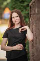 Portrait of a beautiful young beautiful girl in a black T-shirt and black jeans.