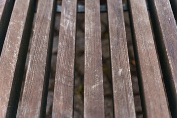 Brown wooden bench made of smooth beams.