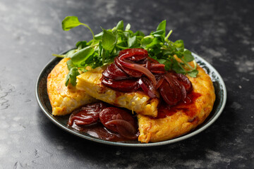 Spanish tortilla with spicy chorizo sausages in sauce