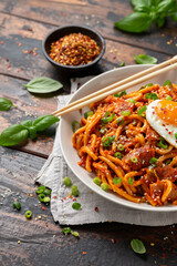 Kimchi Fried Udon Noodle with Fried Egg and bacon. Korean food.