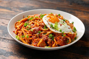 Kimchi Fried Udon Noodle with Fried Egg and bacon. Korean food.