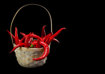 Red hot pepper in a basket on a dark background.