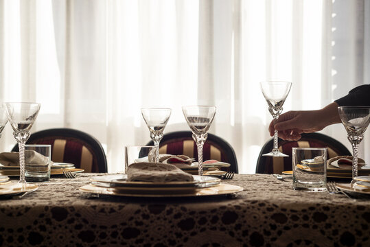 Unrecognizable woman organizing elegant Christmas meal. Close up photo of female hands setting the table for Christmas meal at home.