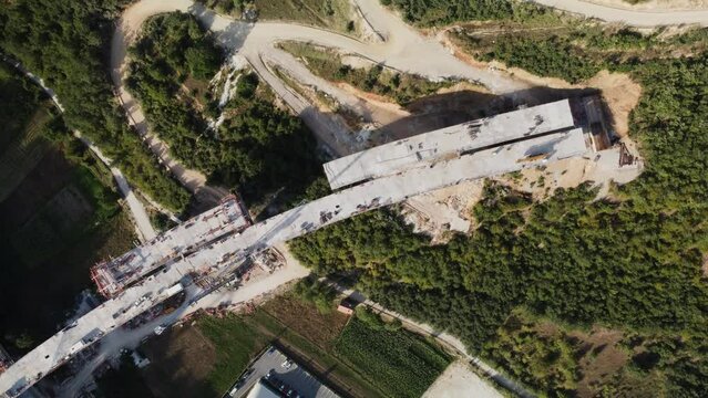Highway bridge under construction. Aerial view of nes road. Freeway being built on a mountain terrain..