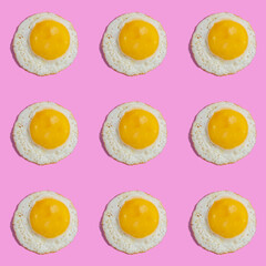 Seamless pattern with sunny side up egg on pink background.