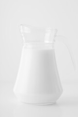 Pitcher of milk isolated on white background. Glass jug