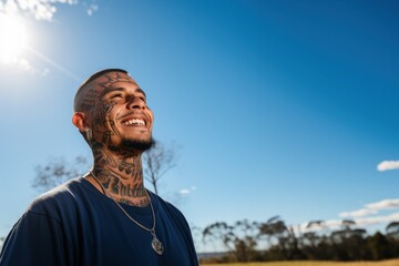Young man with neck and face tattoos smiling having hope