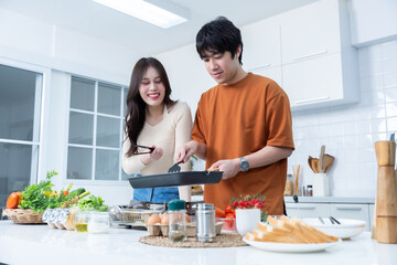 asian of having fun standing a cheerful see grilled meat preparing food and enjoy cook cooking with vegetables, meat, bread while standing on a kitchen Condo life or home
