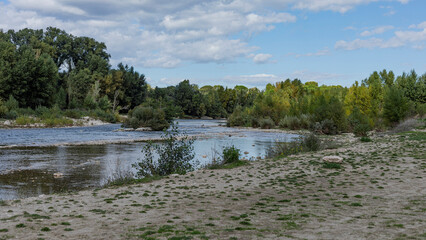 A river flowing into the distance with a sandy beach