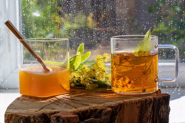 Linden flowers tea. In glass cup. With honey. On wooden stand. Linden flowers tea. In glass cup....