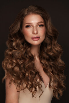 Beautiful brown-haired girl with a perfectly curls hair, and classic make-up. Beauty face and hair.