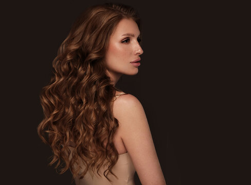 Beautiful brown-haired girl with a perfectly curls hair, and classic make-up. Beauty face and hair.
