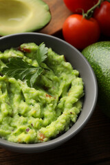 Delicious guacamole and different ingredients on table, closeup