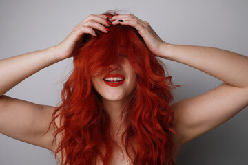 Smiling young woman with long red hair posing on white background. Mock-up.