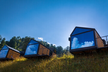 Tourist cabins for rent in a picturesque mountainous area, glamping, tent camp in the mountains, selective focus