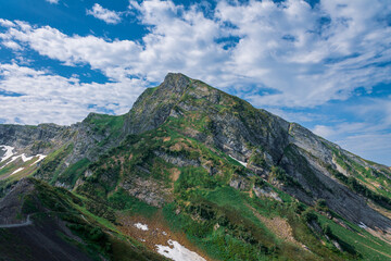 picturesque beautiful panorama view of the mountain gorge mountain ranges covered with greenery forests and snow against the background of the blue sky