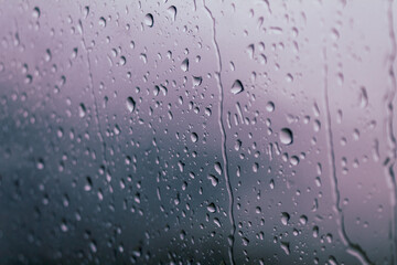 Drops of water on glass on a cold background, rainy weather high humidity, worsening weather forecast selective focus