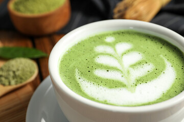 Delicious matcha latte in cup on table, closeup