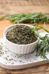 Dry and fresh tarragon on wooden table