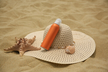 Sunscreen, hat and starfish on sand. Sun protection care