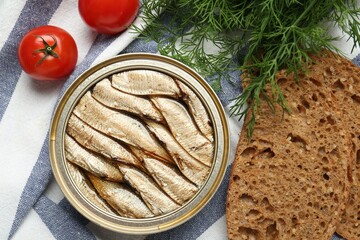Canned sprats, dill, tomatoes and bread on table, flat lay