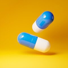 Falling antibiotic pill capsules isolated over yellow background. Healthcare and medical concept. 3D rendering.