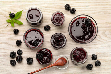 Tasty blackberry jam and fresh berries on white wooden table, flat lay