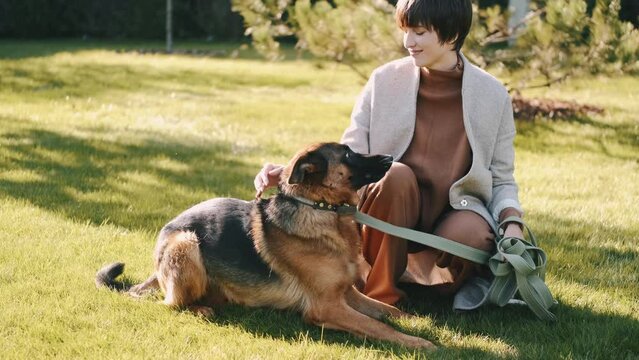 mom with her son in the garden with there dog sitting and playing near the trees