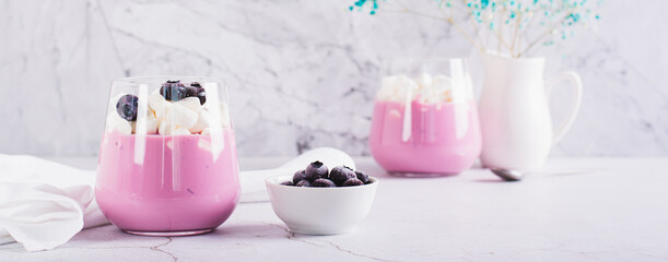 Cocktail with blueberry yogurt and marshmallows in a glass on the table web banner