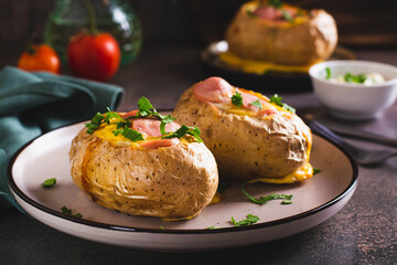 Baked whole potatoes with egg, sausages and herbs on a plate