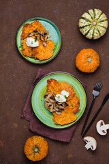 Pumpkin fritters with mushrooms and cream cheese on a green plate on a brown concrete background. Pumpkin recipes.