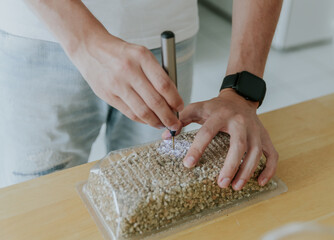 A young man drills a box with a mini drill.