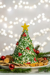 appetizer of Christmas tree made of cheese and decorated with herbs