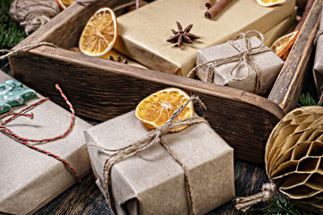 Fototapeta na wymiar Wrapping rustic eco Christmas packages with brown paper and string on dark background