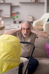 Old man looking after newborn at home