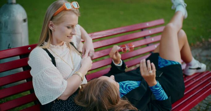 Woman talking to female friend on bench