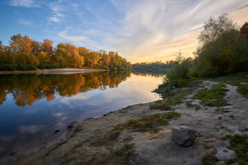 autumn landscape with river and forest at the sunset