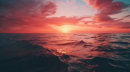 Fototapeta na wymiar The sun is setting over the ocean with waves