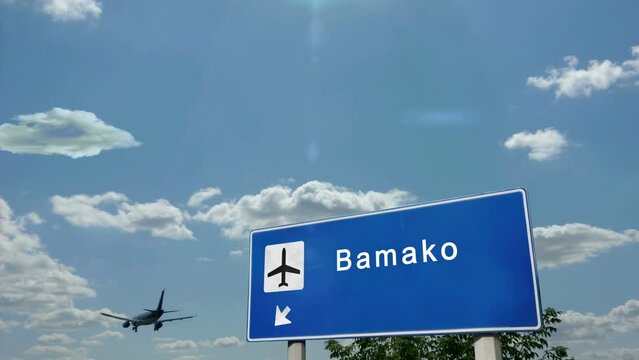 Jet airplane landing in Bamako, Mali. Plane city arrival with airport direction sign. Travel, business, tourism and plane transport concept.