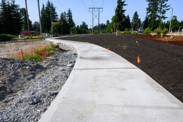 New residential community construction site, freshly poured concrete sidewalk and landscaping...