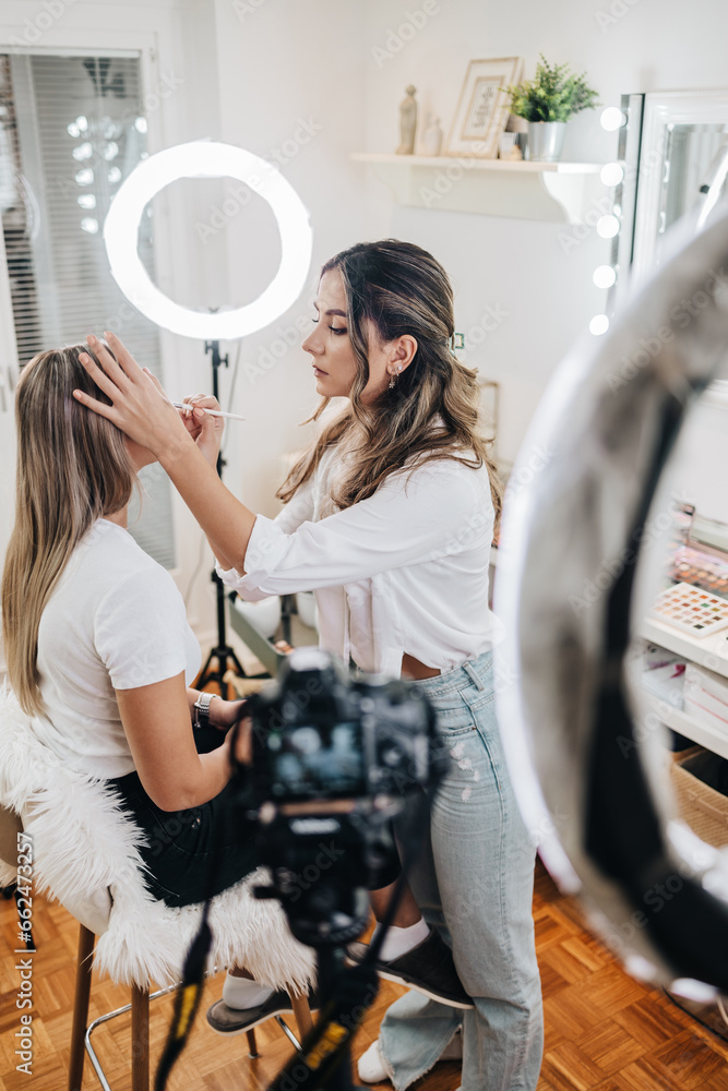 Wall mural happy young woman streaming a beauty makeup vlog from home or workshop. beautiful online content cre