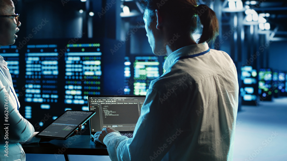 Poster engineering coworkers programming scripts on tablet and laptop, updating data center equipment desig