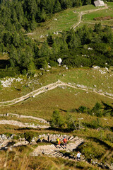 Blick ins Tal an steiler Hangkante mit Wanderern auf Wanderweg