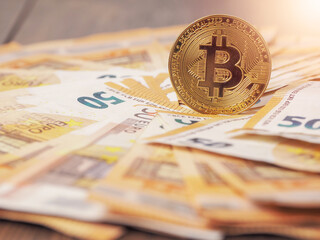 Golden bitcoin standing on euro bank notes. Time to invest into crypto currency concept. Economy and financial background. Get rich theme.