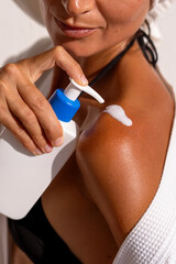with the procedure of applying moisturizer to a woman's shoulder