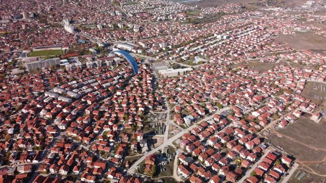 Person paragliding over eastern european town. Aerial drone video of Prilep in North Macedonia.